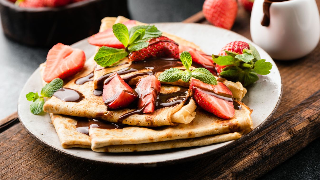 French,Crepes,With,Strawberries,And,Chocolate,Sauce,On,A,Plate
