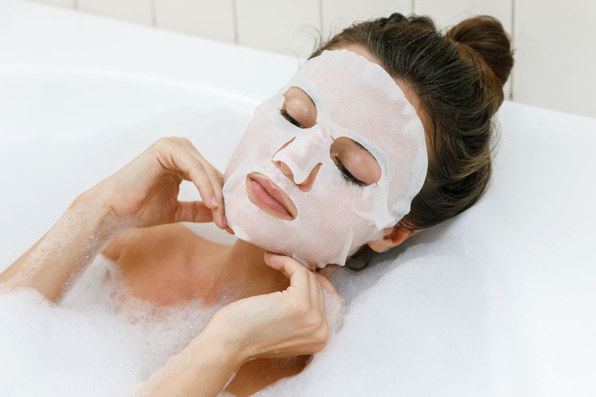 Woman,Lying,In,Bathtub,With,A,Sheet,Mask,On,Her