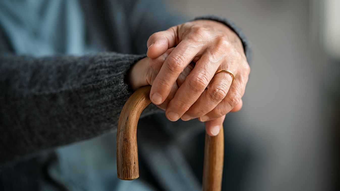 Close,Up,Of,Senior,Disabled,Woman,Hands,Holding,Walking,Stick.