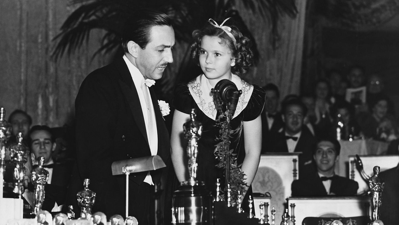 Walt Disney and Shirley Temple at Oscars
A gyermeksztár, Shirley Temple Oscar-díjat és hét miniatűr szobrocskát ajándékoz az amerikai animátornak és producernek, Walt Disney-nek (1901-1966) első nagyjátékfilmjéért, a Hófehérke és a hét törpeért.
