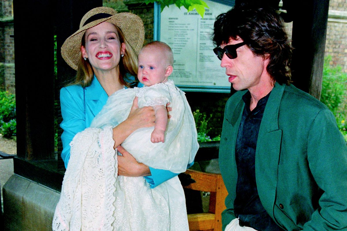 Jerry Hall (L) and singer of The Rolling Stones, Mick Jagger with their daughter Georgia May Jagger during her christening at Saint Andrew's church, Richmond 1992