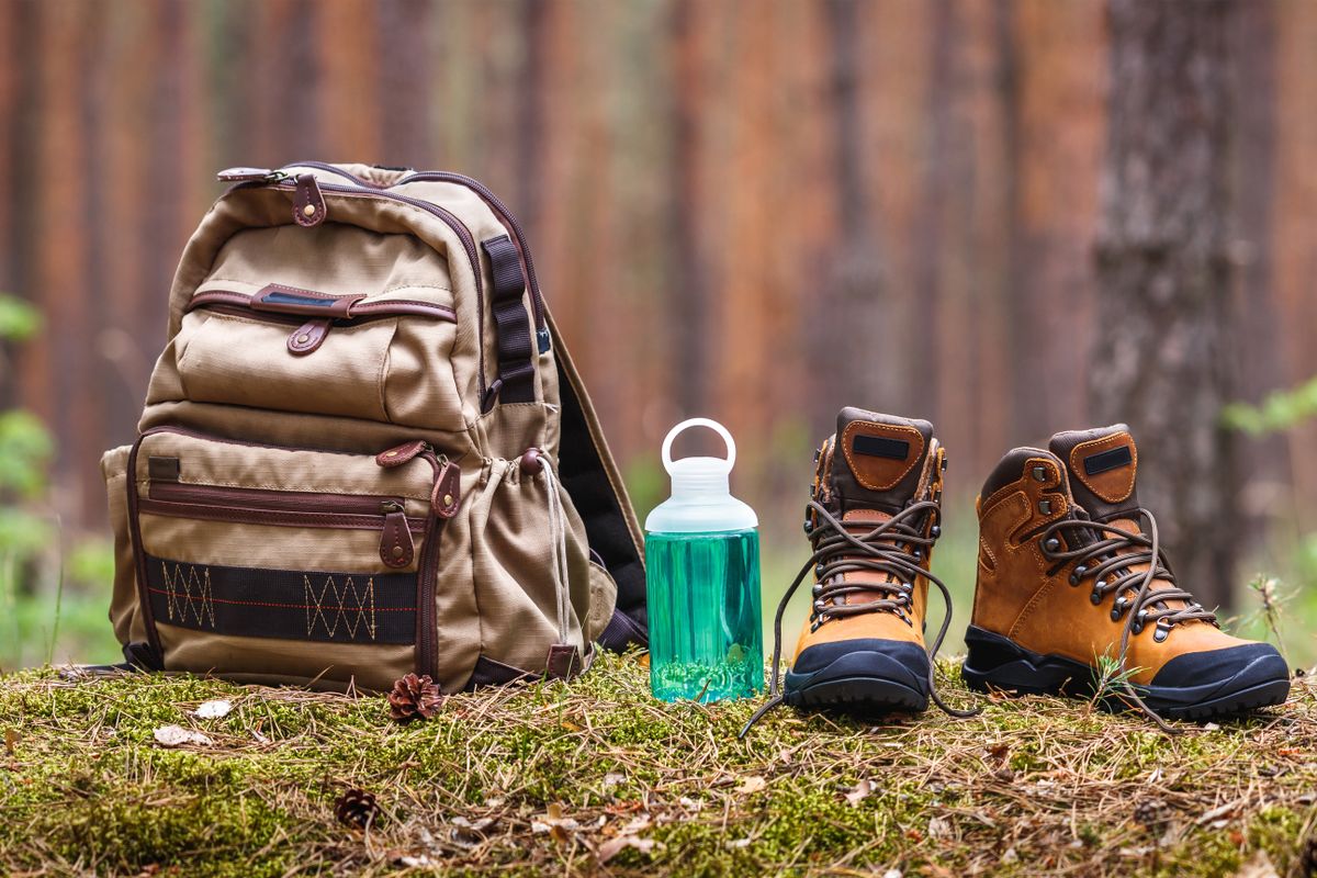 Hiking,And,Camping,Equipment,In,Forest.,Backpack,,Water,Bottle,And
