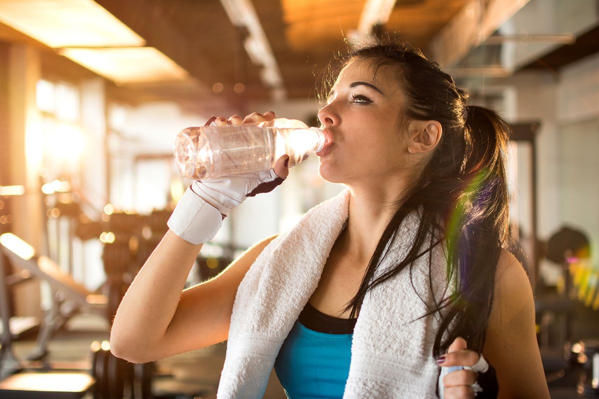 Young,Athletic,Woman,Drinking,Water,In,Gym.