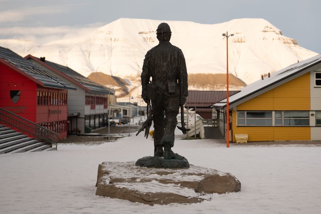 Longyearbyen sétálóutcája és a bányászok emlékműve, háttérben a Hiorthfjellet hegy.