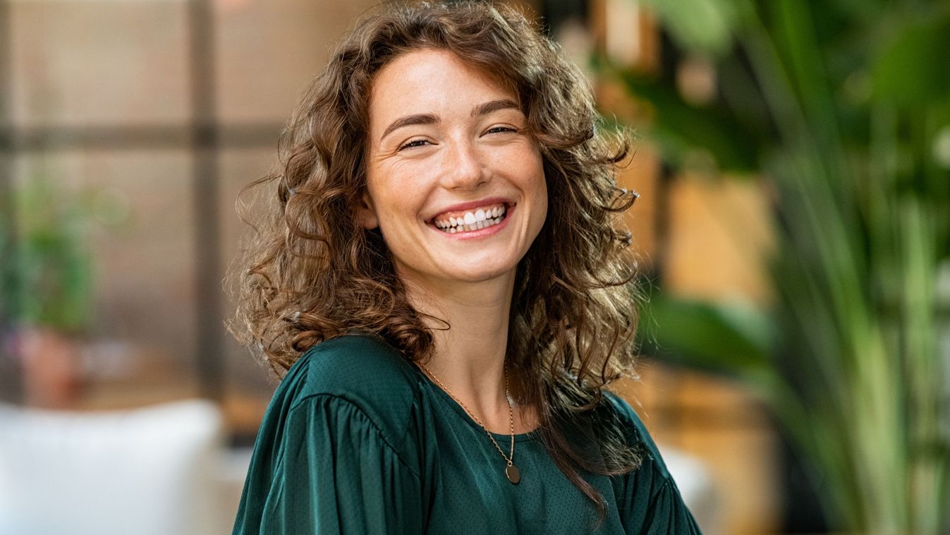 Portrait,Of,Young,Smiling,Woman,Looking,At,Camera,With,Crossed