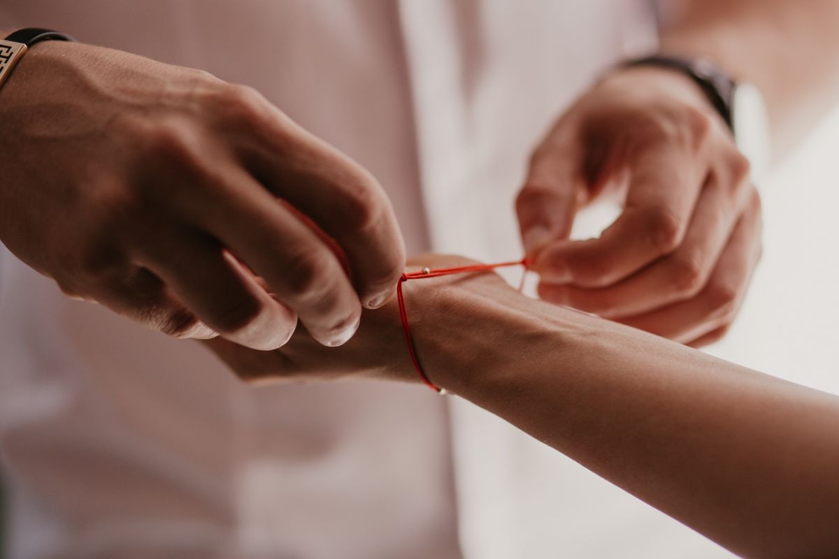 Man,Ties,A,Red,Bracelet,On,Woman's,Hand,,Red,Thread,