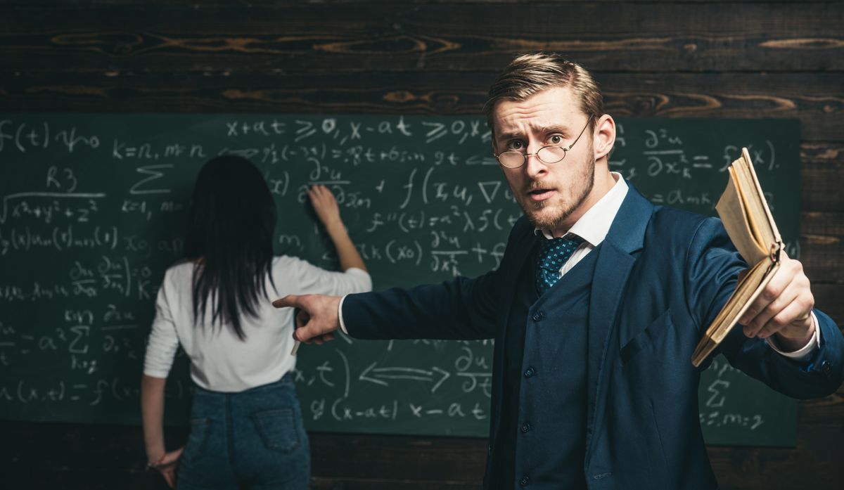 Agitated,Young,Professor,With,Stylish,Mustache,And,Beard,Pointing,Book