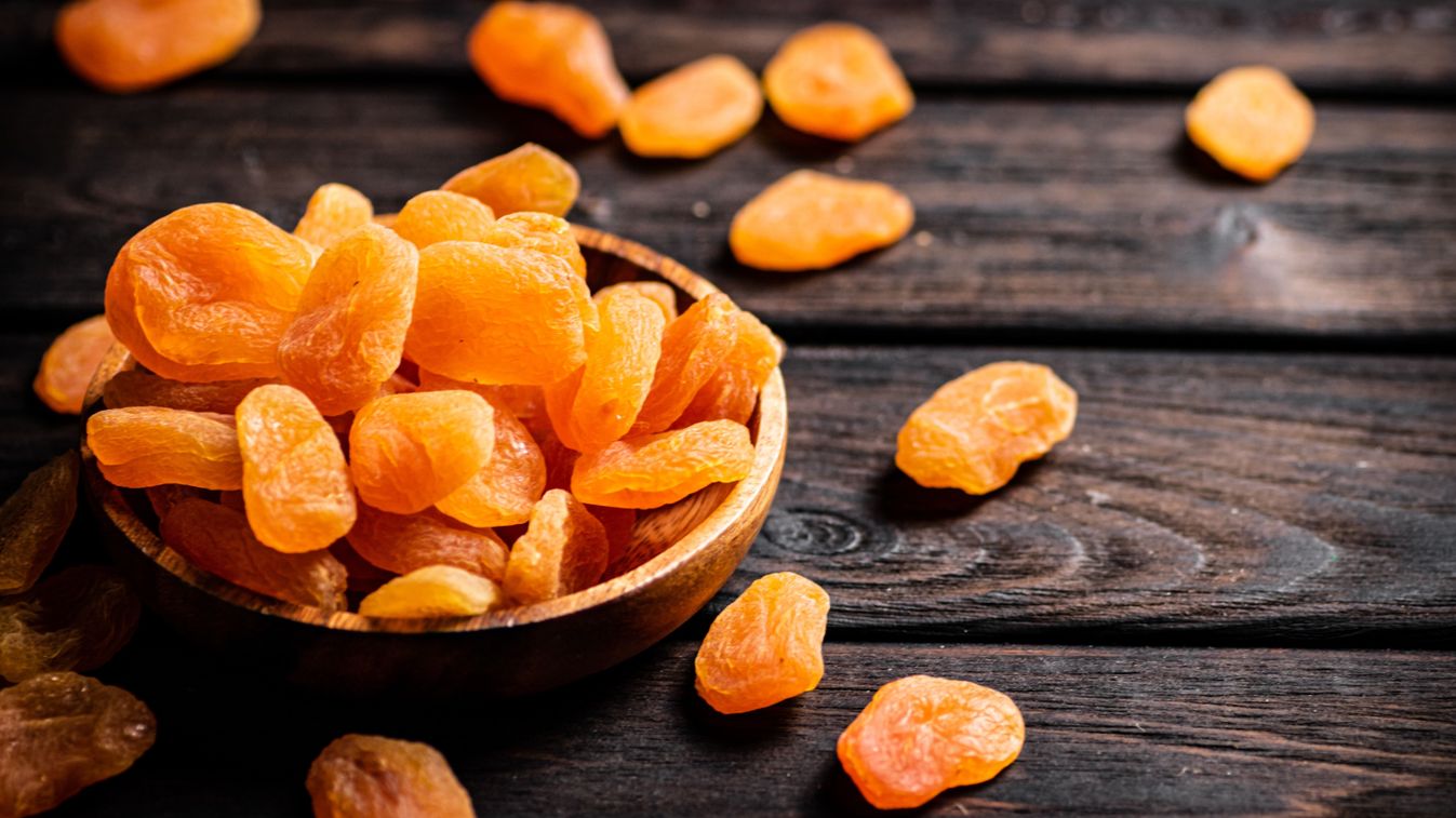 A,Full,Plate,Of,Dried,Apricots.,On,A,Wooden,Background.