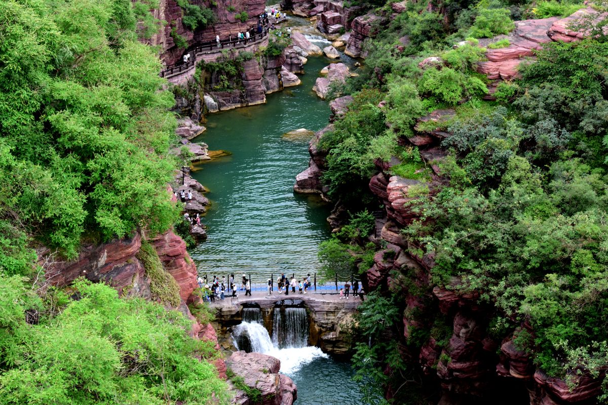 Turisták a Yuntai parkban, ahol a vízesés is található, Kína