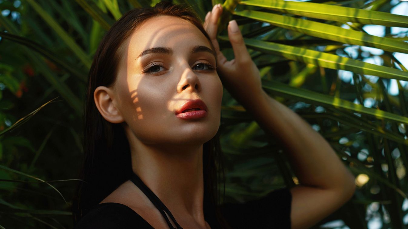 Beautiful,Girl,In,Palm,Leaves.,Young,Woman,With,Make-up,Under