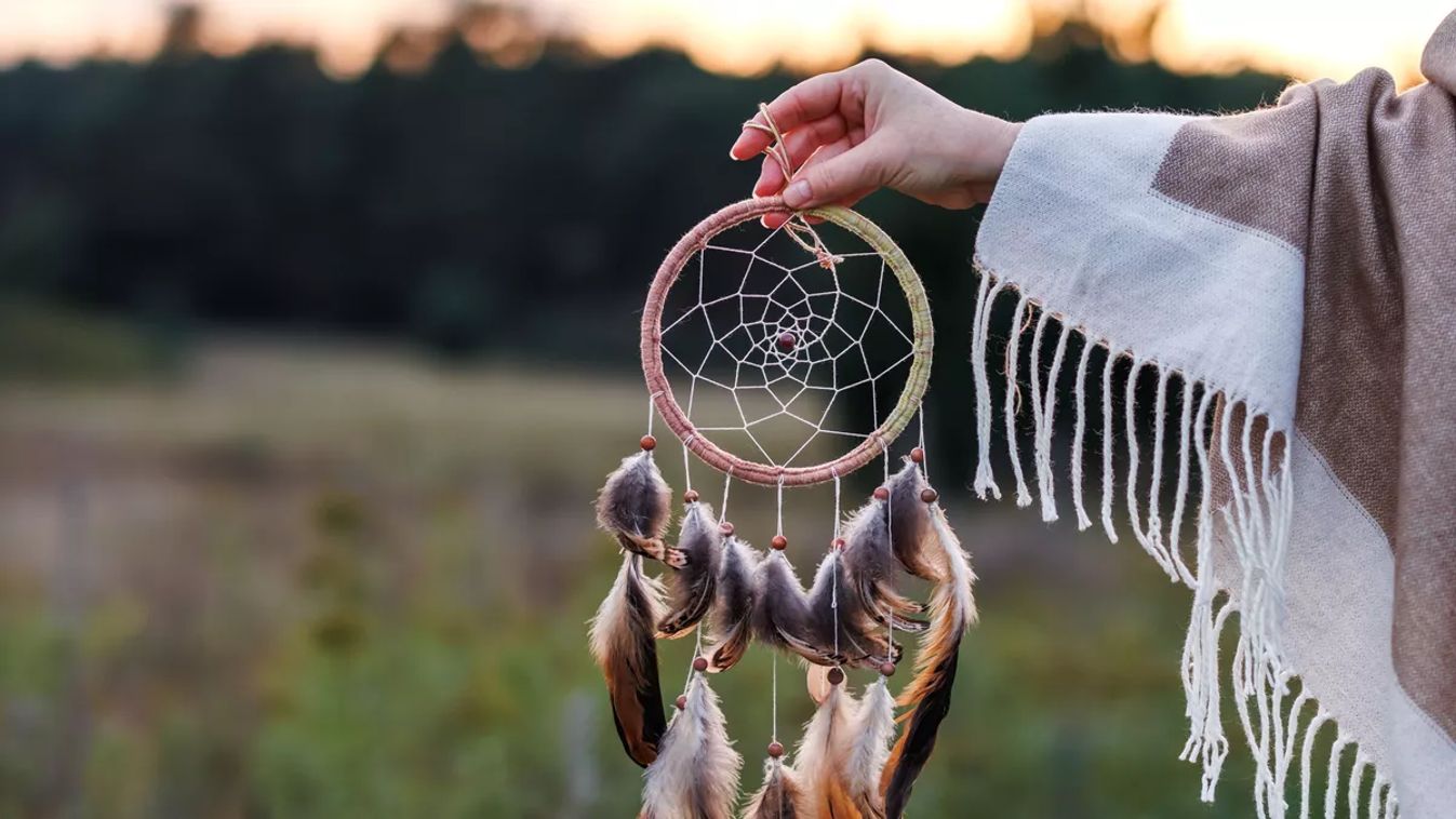 Woman,With,Poncho,Holding,Dreamcatcher,During,Sunrise.,Spirituality,And,Harmony