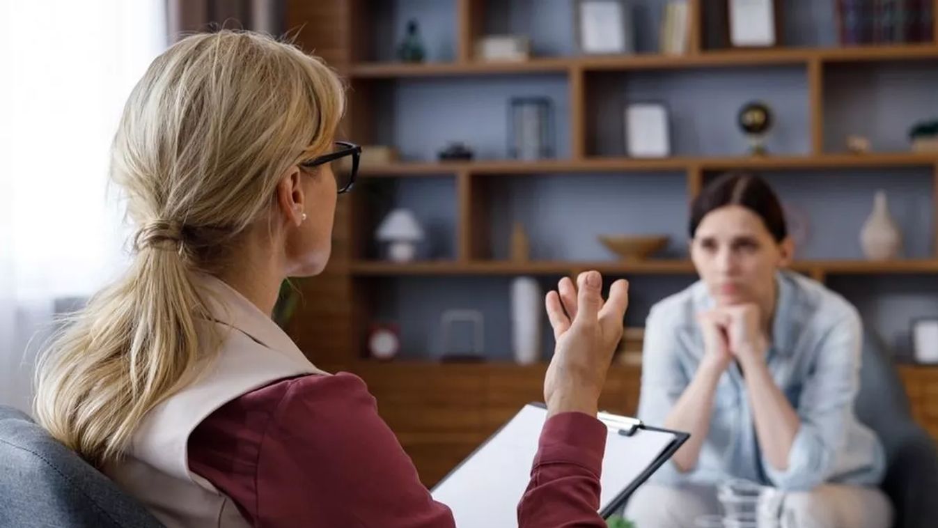 Over,Shoulder,View,Of,Female,Psychologist,Sitting,In,Armchair,,Talking