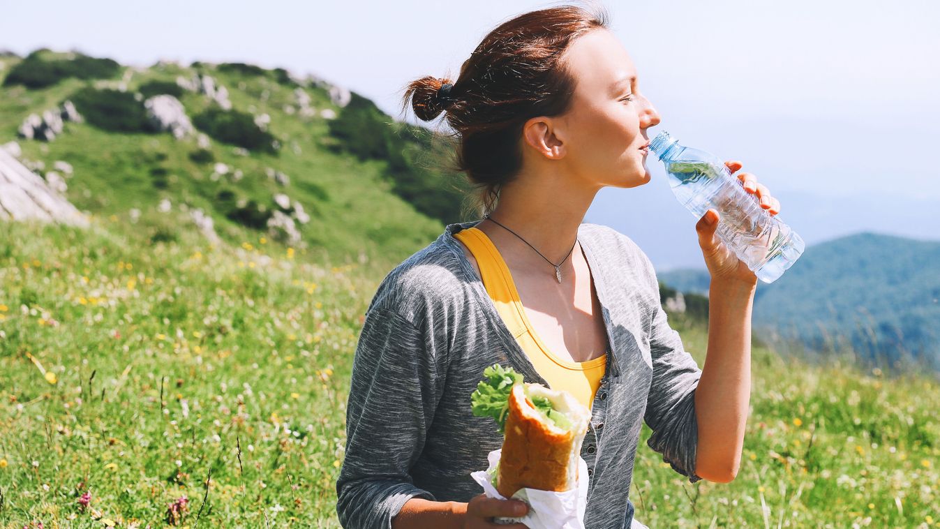 Beautiful,Young,Woman,Drinking,Still,Water,And,Eating,Vegetarian,Sandwich