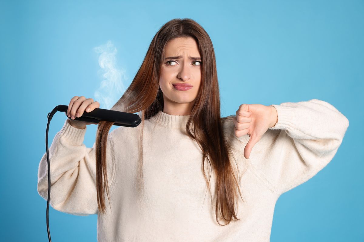 Upset,Young,Woman,With,Flattening,Iron,Showing,Thumb,Down,On