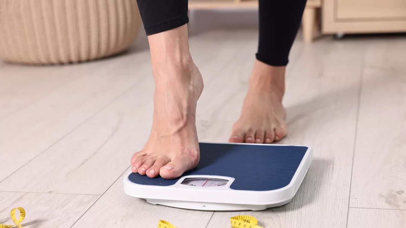 Woman,Stepping,On,Floor,Scale,And,Measuring,Tape,At,Home,
mérleg fogyás diéta