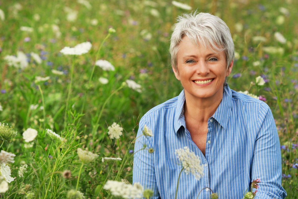 Happy,Attractive,Senior,Woman,In,A,Flower,Field,In,Summer