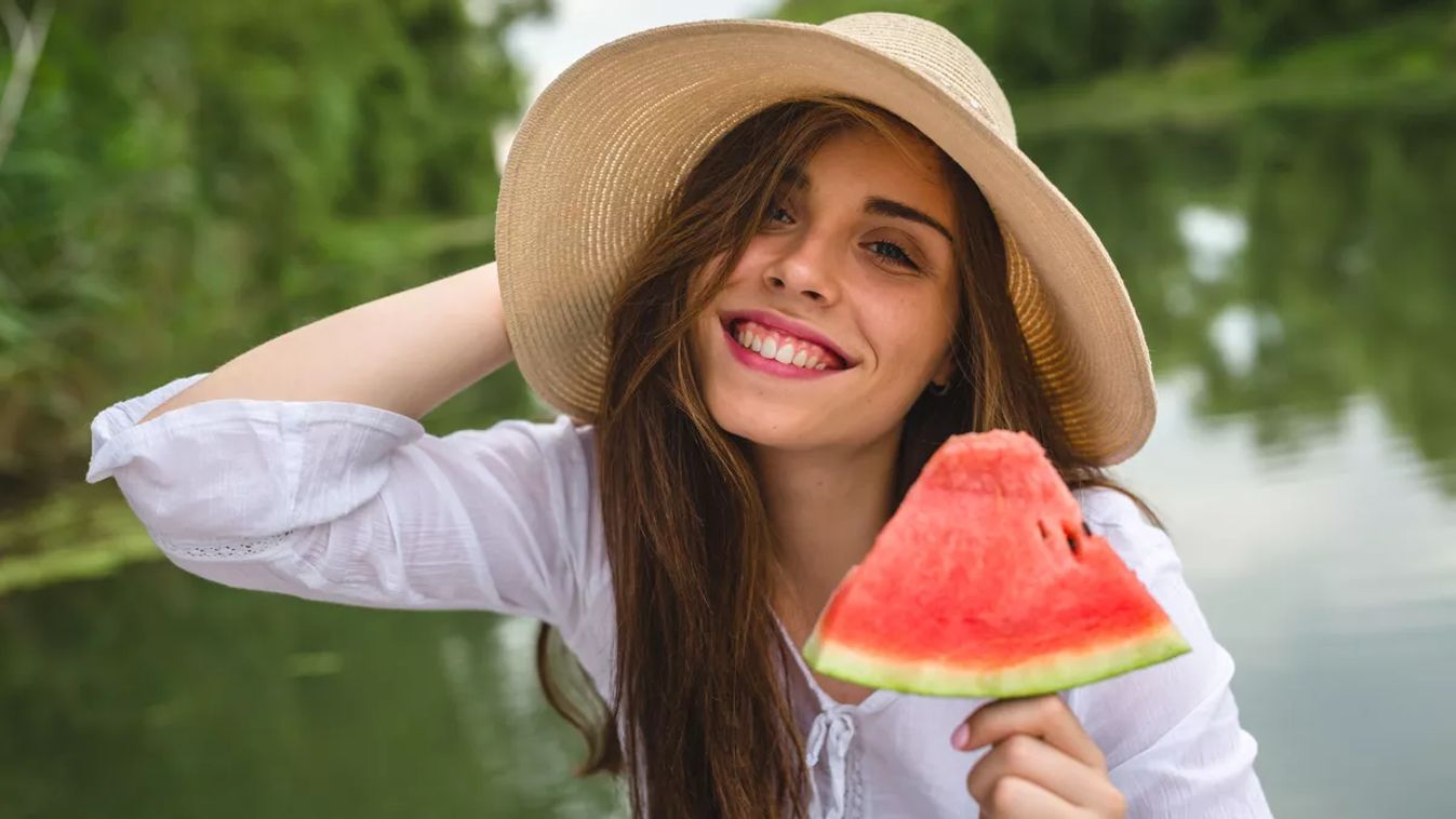 Woman,With,Hat,Eating,Watermelon,By,The,River