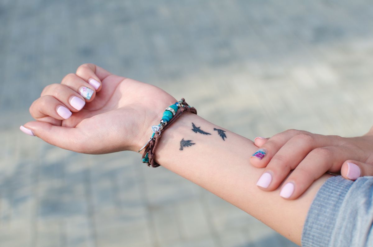 Bracelet,On,The,Arm,With,Tattoo