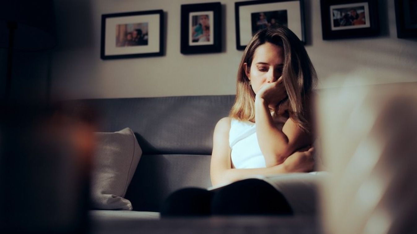 Sad,Depressed,Woman,Alone,At,Home,Sitting,On,A,Sofa.