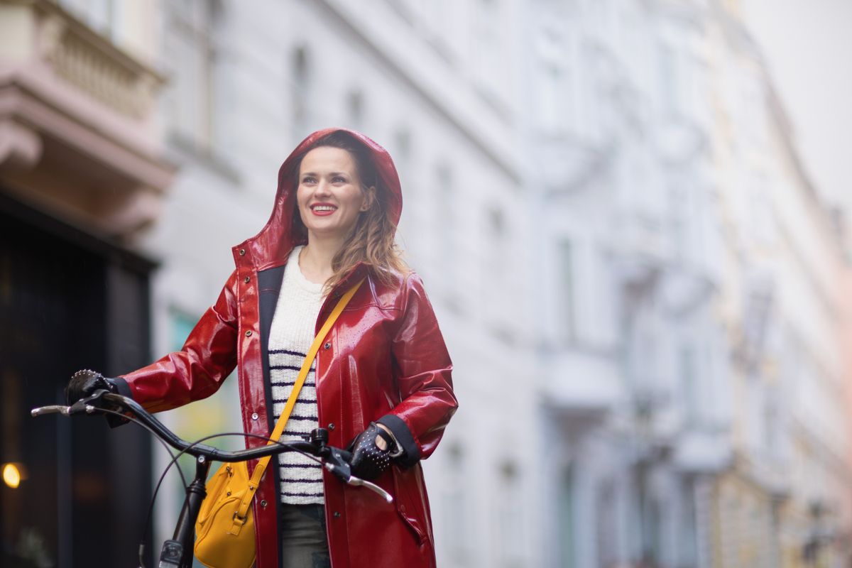 Happy,Elegant,Woman,In,Red,Rain,Coat,With,Bicycle,In