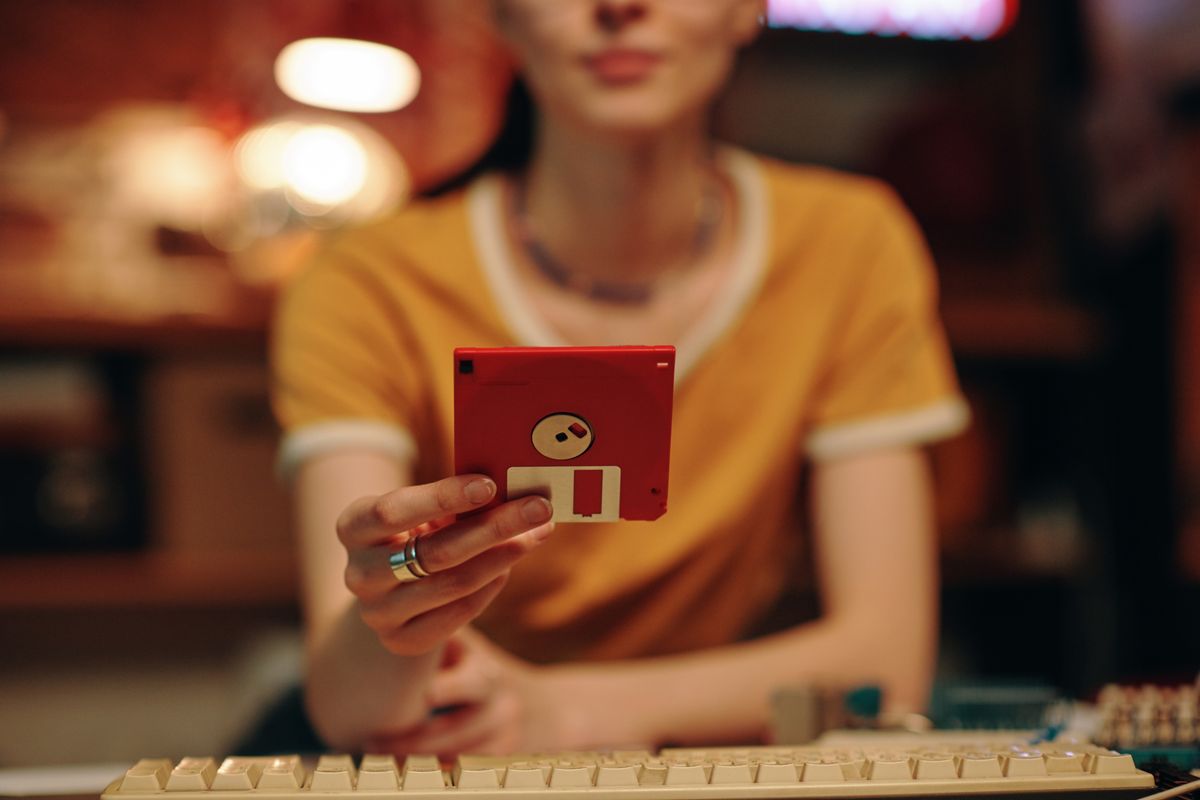 Close-up,Of,Young,Woman,Saving,Information,On,Floppy,Disk,While