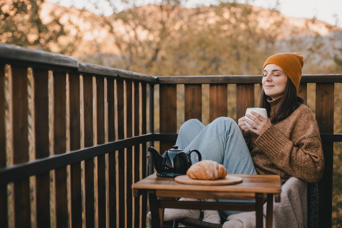 Young,Woman,In,Knitted,Sweater,And,Hat,Drinking,Tea,And