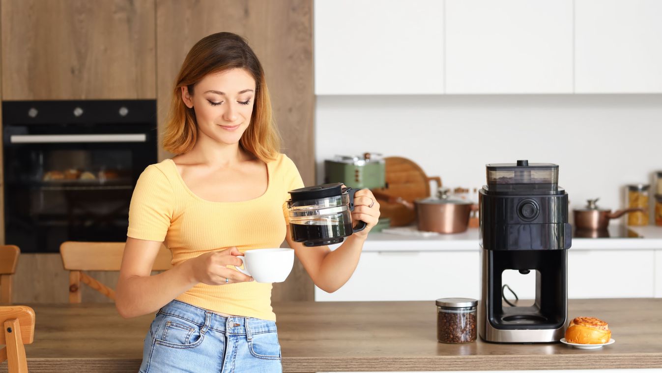 Young,Woman,Pouring,Coffee,Into,Cup,In,Kitchen