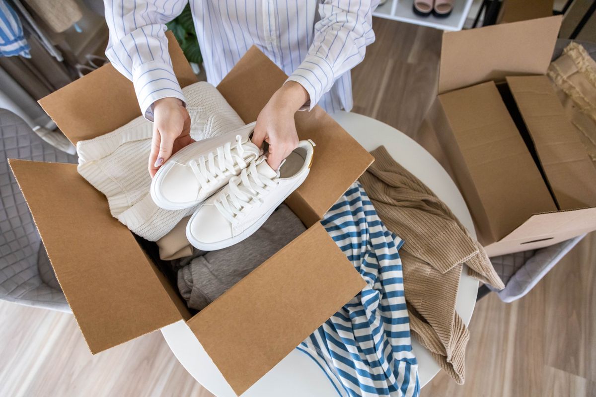 Woman,Packing,Clothes,And,Shoes,Into,Cardboard,Box,Seasonal,Comfortable