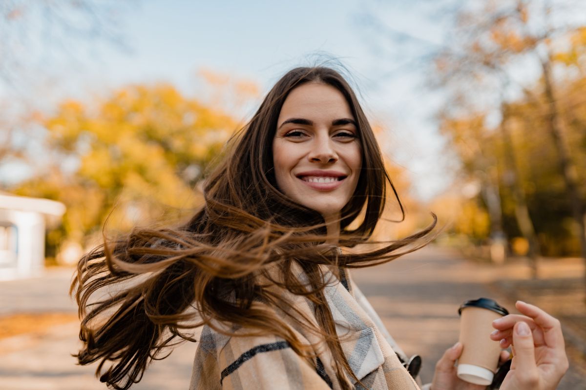 Candid,Attractive,Young,Smiling,Woman,Walking,In,Autumn,Park,With