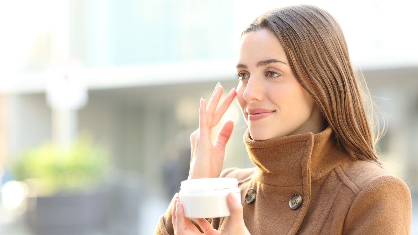 Satisfied,Woman,Applying,Mousturizer,Cream,On,Her,Face,In,Winter