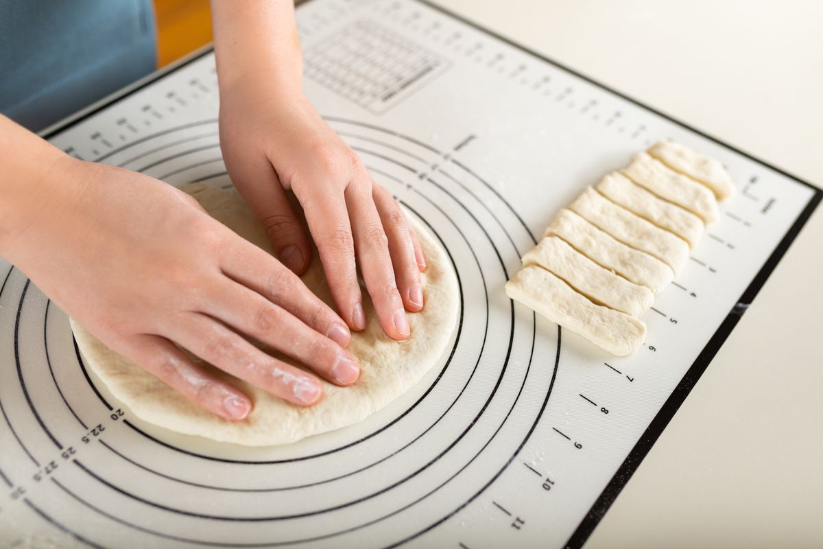 Close-up,Of,Hands,Kneading,Rolled,Out,Dough,On,A,Kitchen