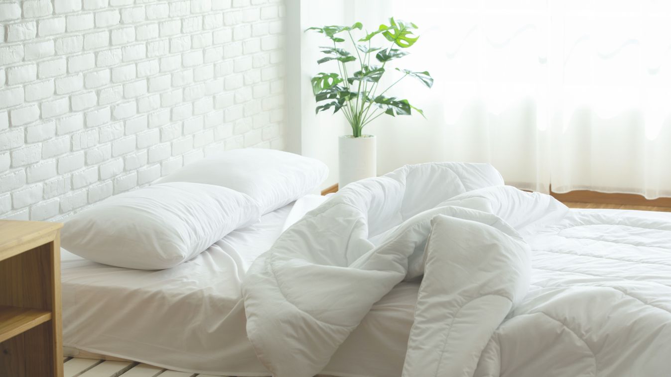 Messed,Bed,With,White,Pillow,And,Blanket,With,Natural,Light