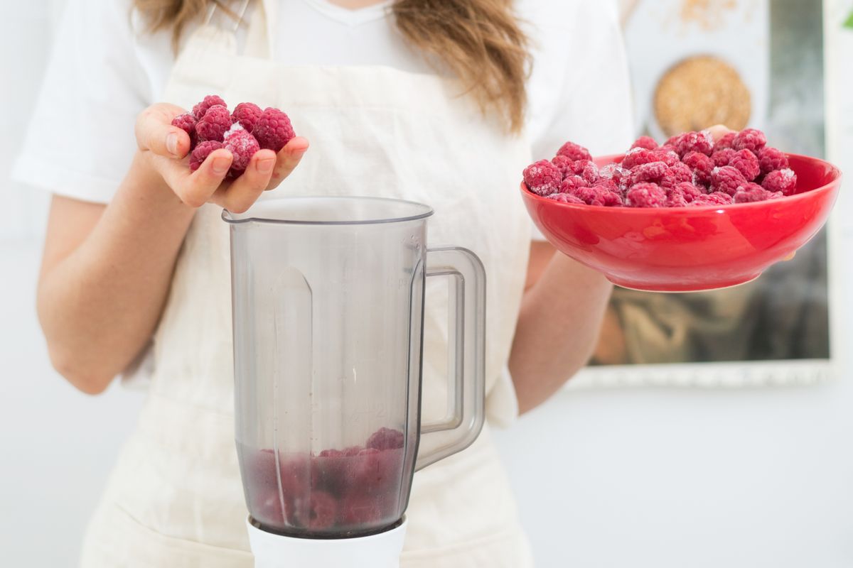 Raspberry,Smoothies,A,Woman,Puts,Fresh-frozen,Raspberry,Berries,In,A