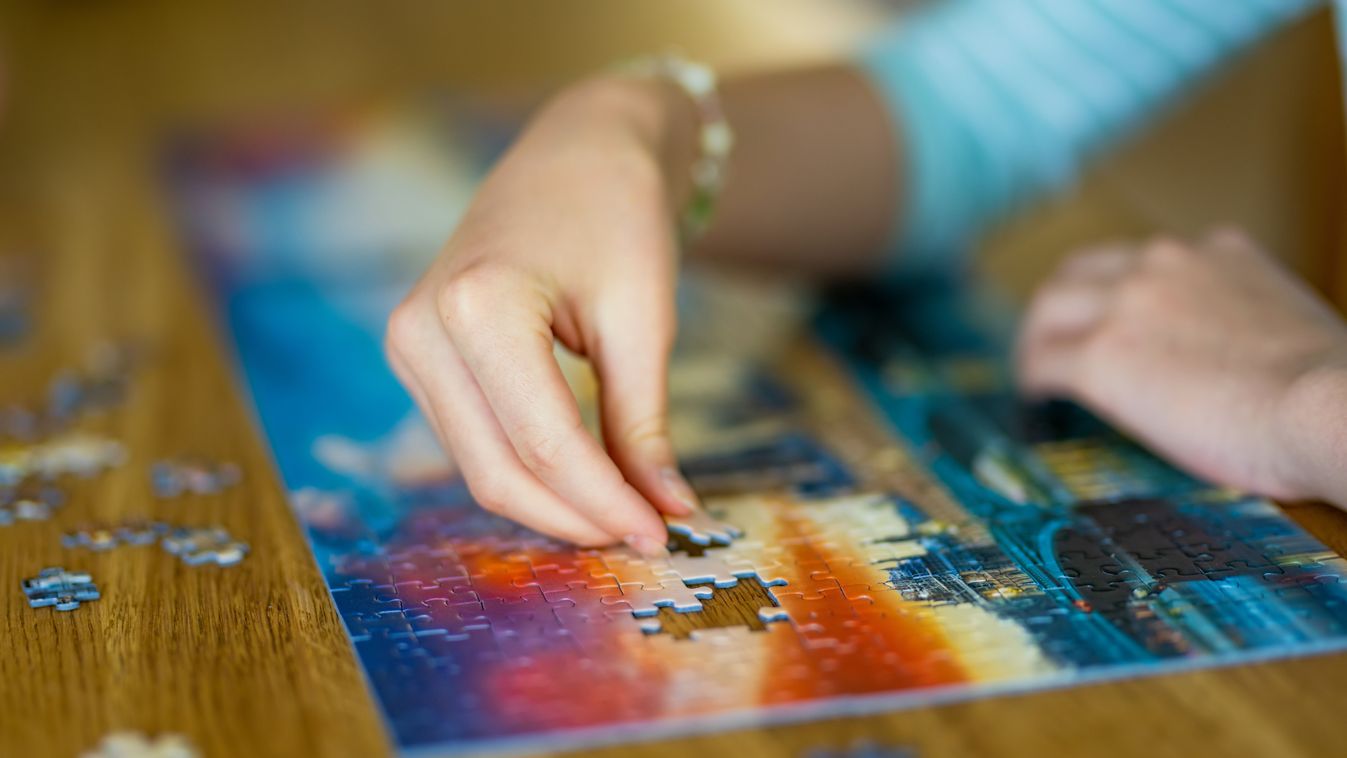 Close-up,On,Woman,Hand,Playing,Puzzles,At,Home.,Connecting,Jigsaw
kirakós játék