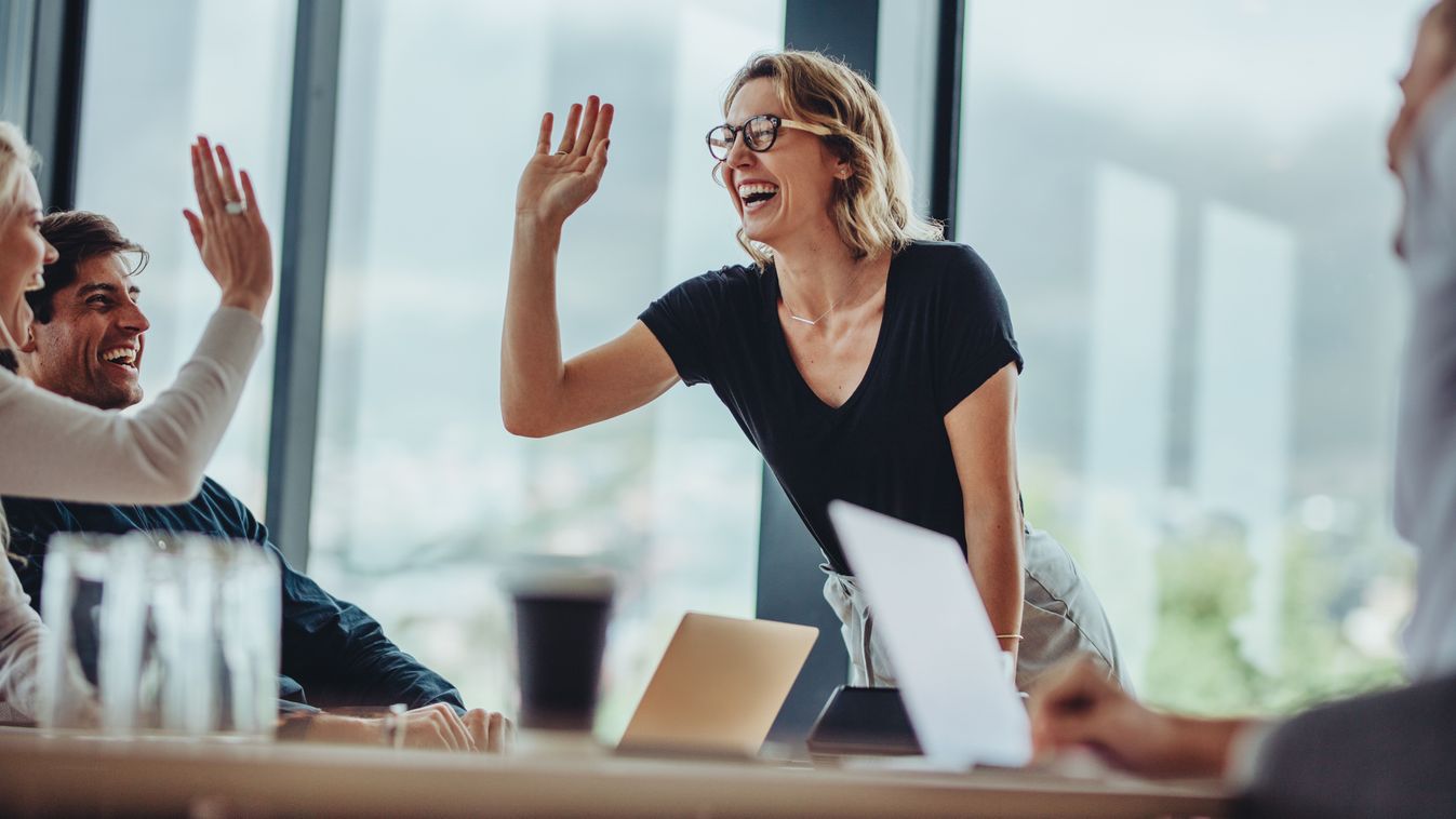 Smiling,Woman,Giving,A,High,Five,To,A,Female,Colleague