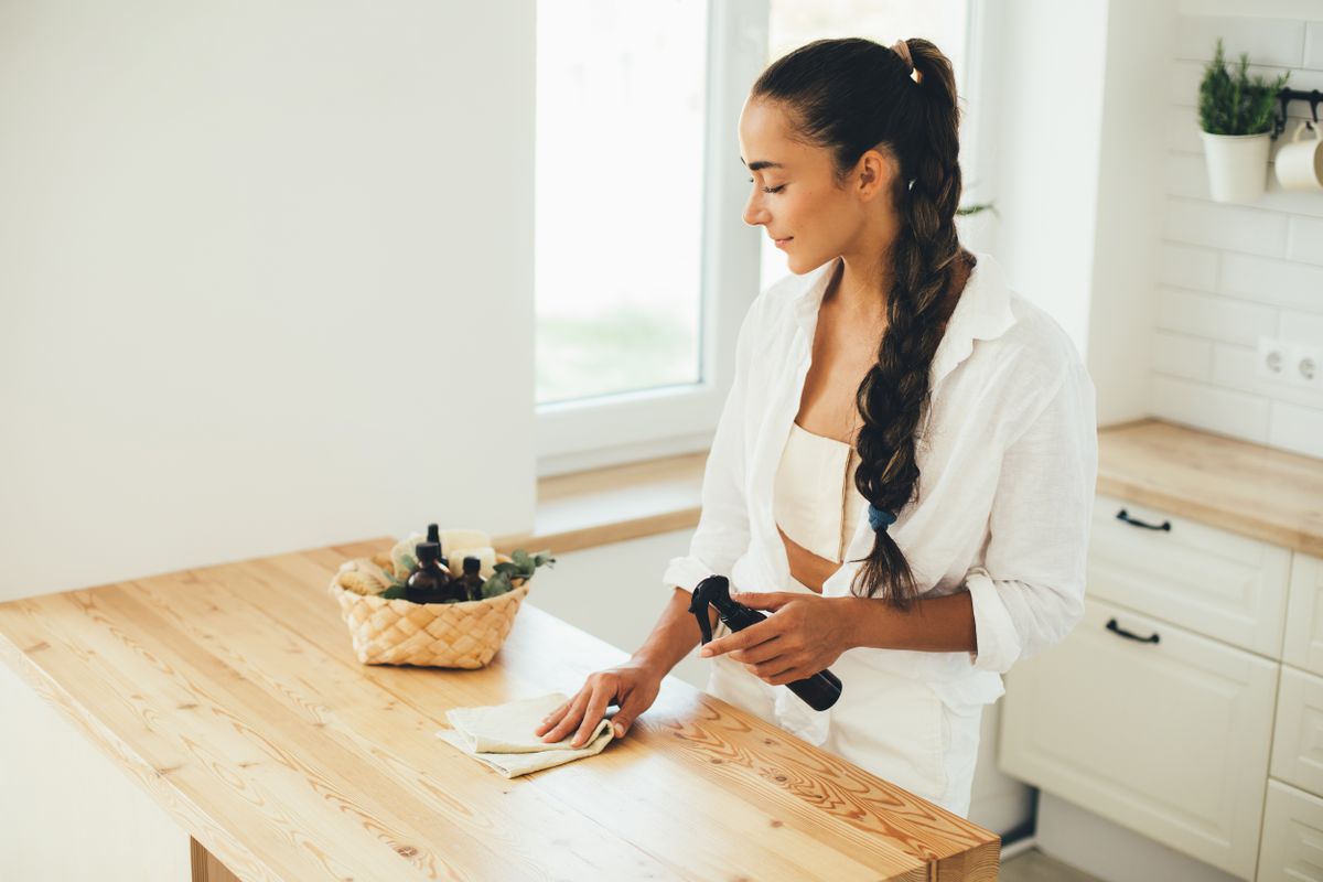 Young,Woman,Cleaning,Wooden,Table,Using,Spray,In,Glass,Bottle