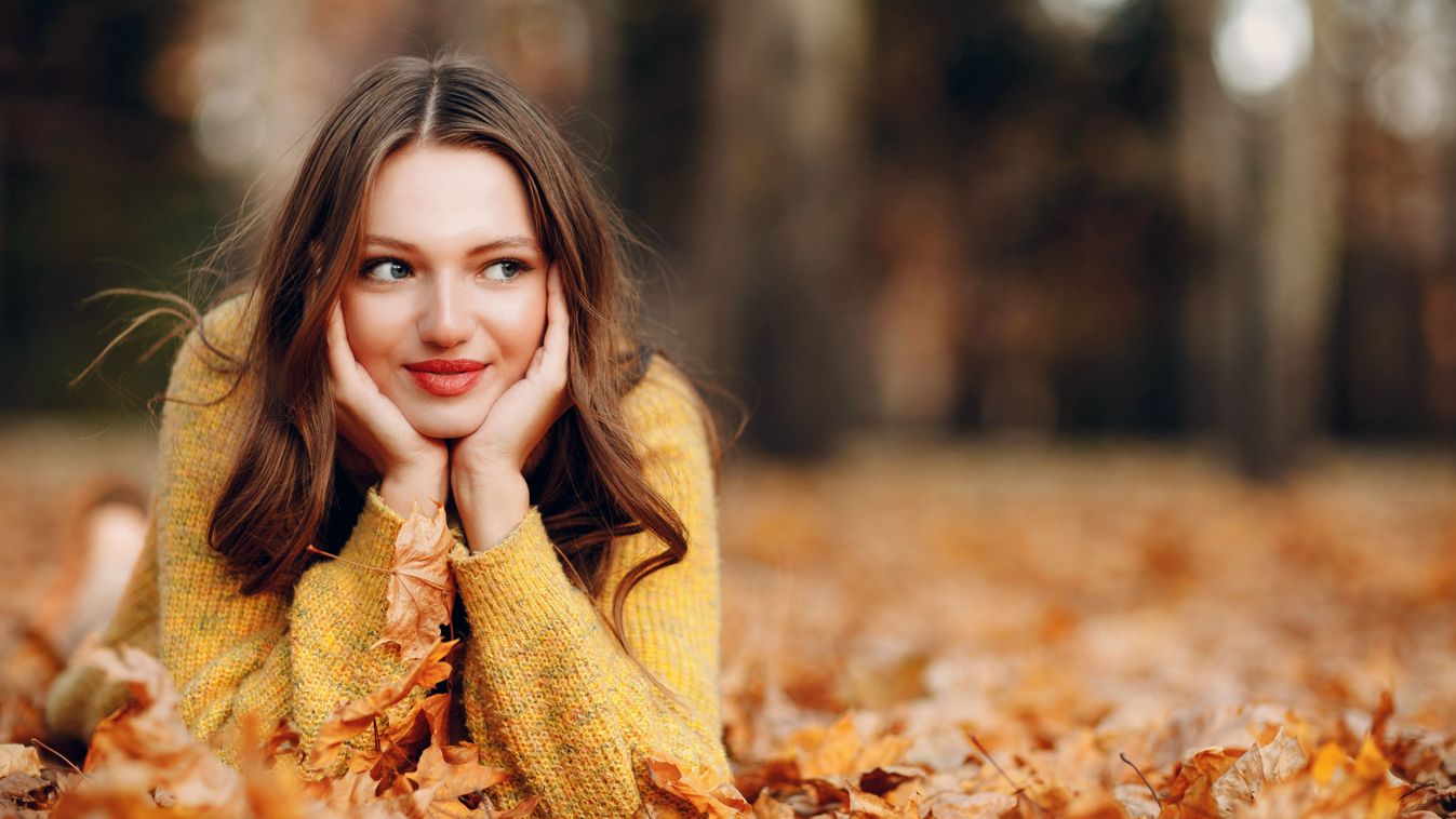 Young,Woman,Lies,In,Autumn,Park,Ground,With,Yellow,Foliage