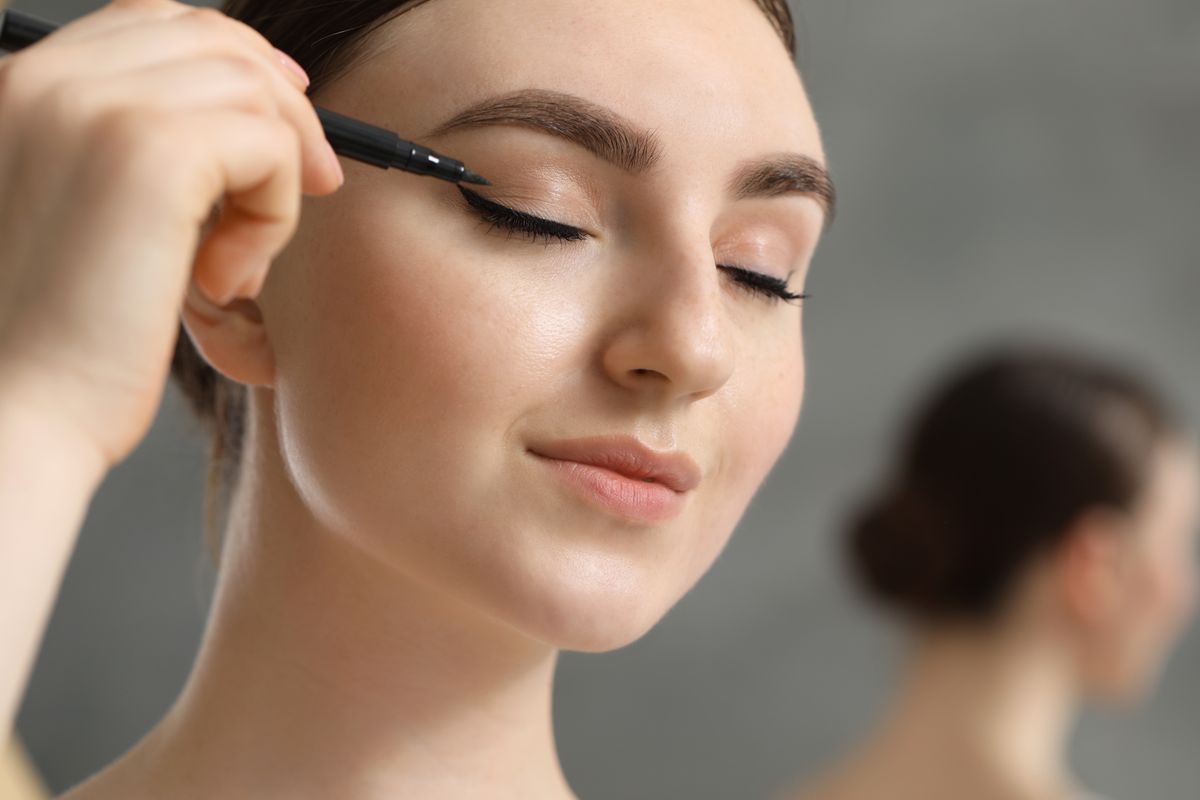 Makeup,Product.,Woman,Applying,Black,Eyeliner,On,Blurred,Background,,Closeup