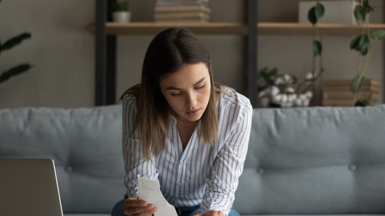 Busy millennial female focused on accounting paperwork at home office