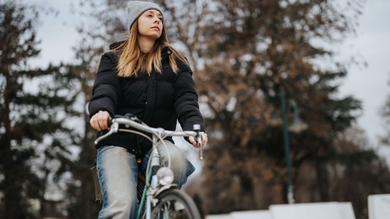 Focused,Young,Woman,Cycling,Through,A,Scenic,Park,With,Autumn