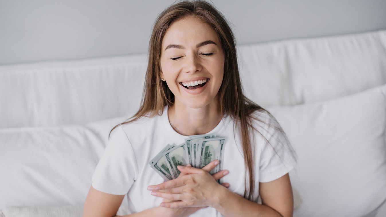 Excited,Blonde,Caucasian,Girl,Broad,Smiling,Eyes,Closed,Presses,Banknotes