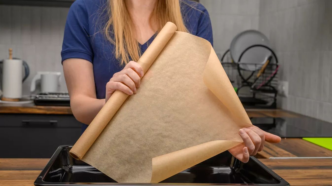 A,Woman,Holds,A,Roll,Of,Brown,Baking,Paper,In