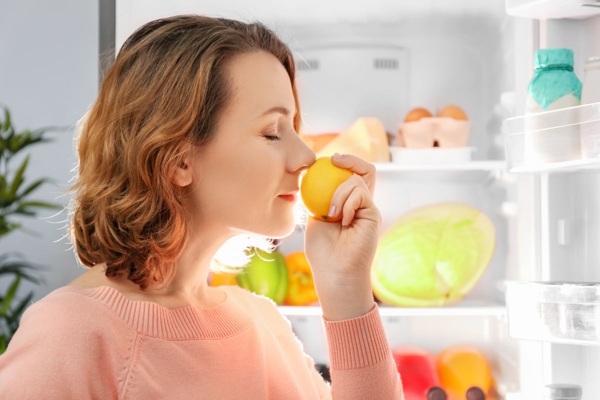 Beautiful,Woman,With,Fresh,Lemon,Standing,Near,Refrigerator