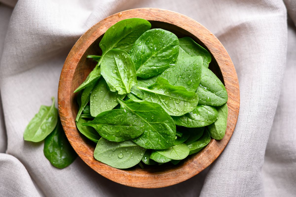 Baby,Spinach,Leaves,With,Water,Drops,In,A,Wooden,Bowl