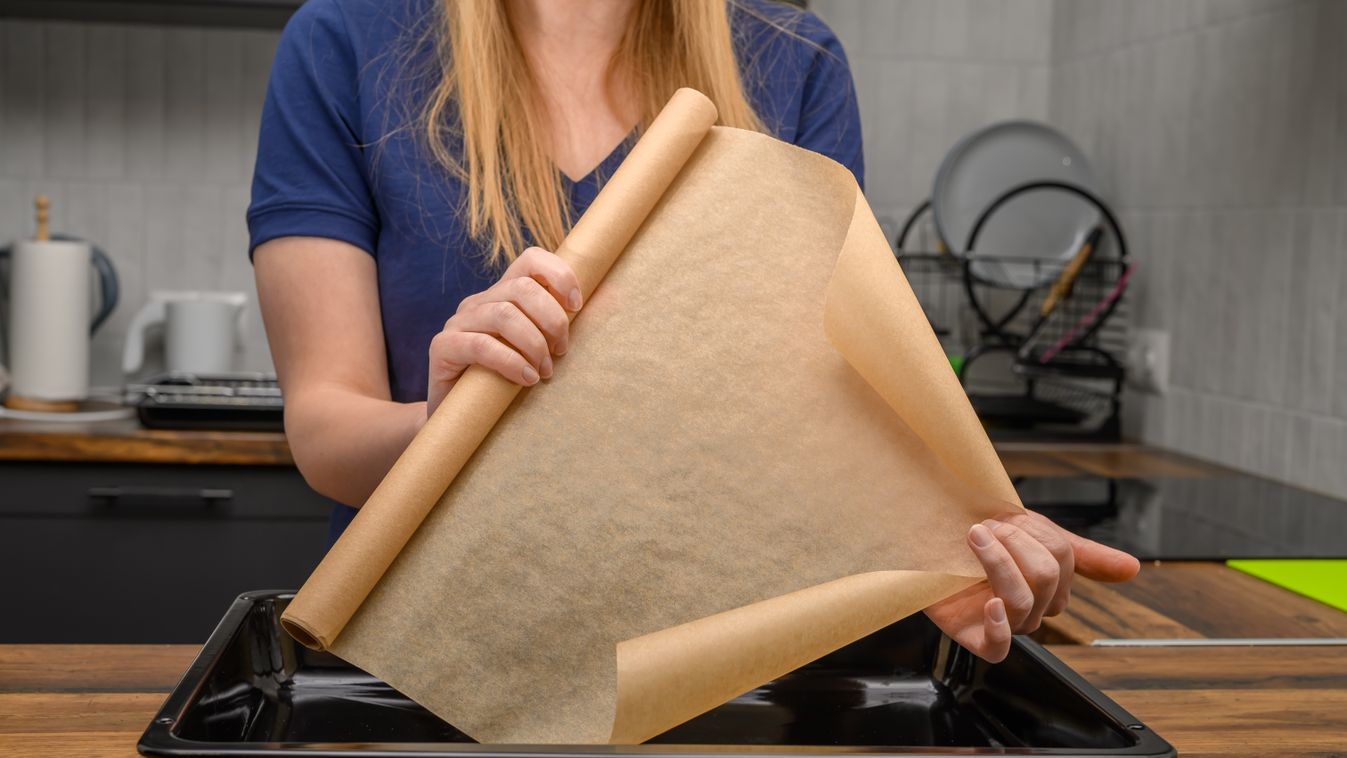 A,Woman,Holds,A,Roll,Of,Brown,Baking,Paper,In