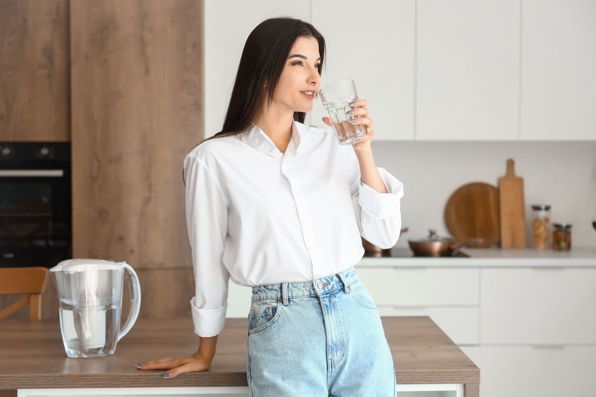 Young,Woman,Drinking,Filtered,Water,In,Kitchen, vízivás