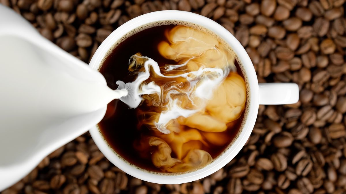 Pouring,Milk,In,Coffee,Cup,,Top,View