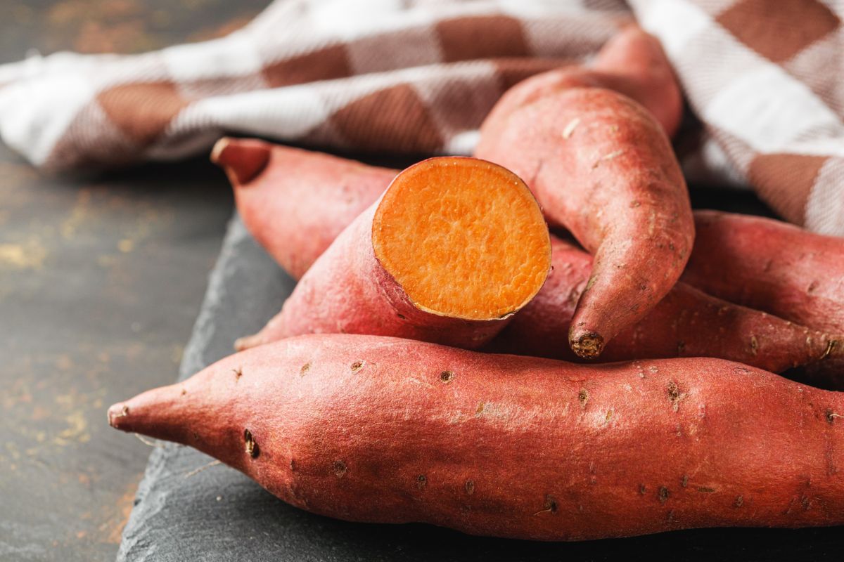 Fresh,Sweet,Potatoes,On,A,Dark,Rustic,Background.