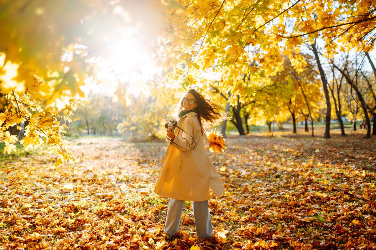 Smiling,Woman,In,A,Light,Coat,With,A,Retro,Camera