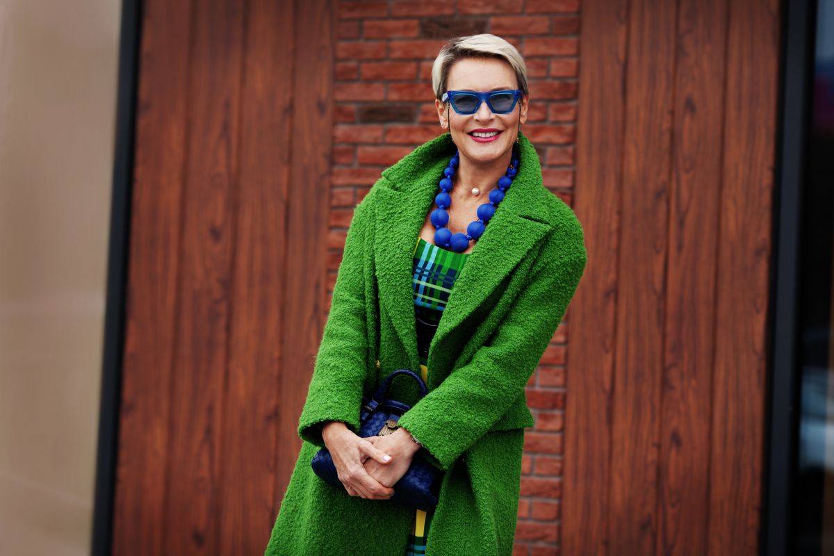 Portrait,Of,Smiling,Stylish,Woman,Wearing,Green,Coat,With,Blue